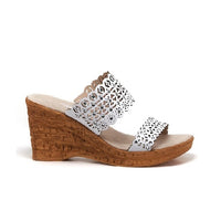 Double strap wedge with jewel and cut out details in white.